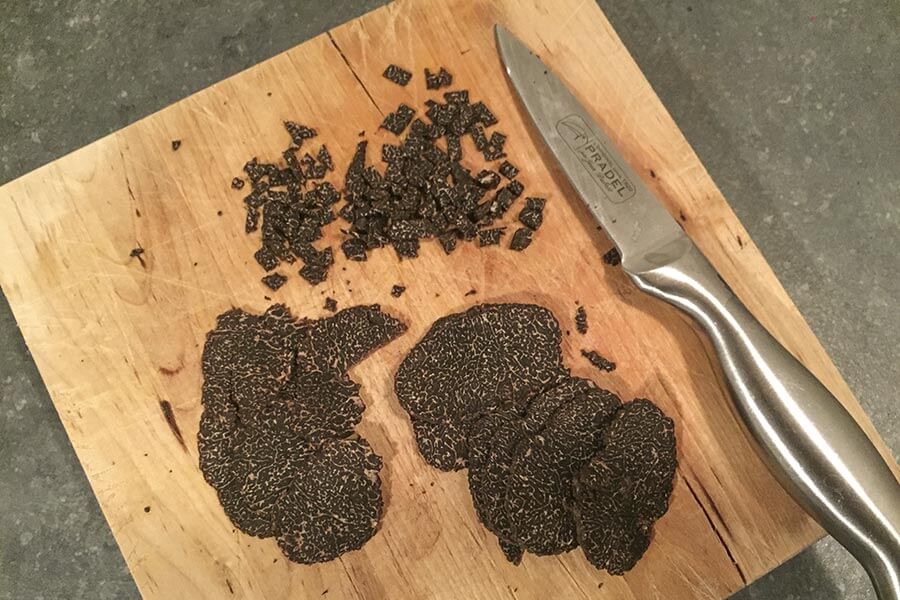 Trueffelrezept-Trueffeln-schneiden Geschnittene Trüffeln auf Brett mit Messer