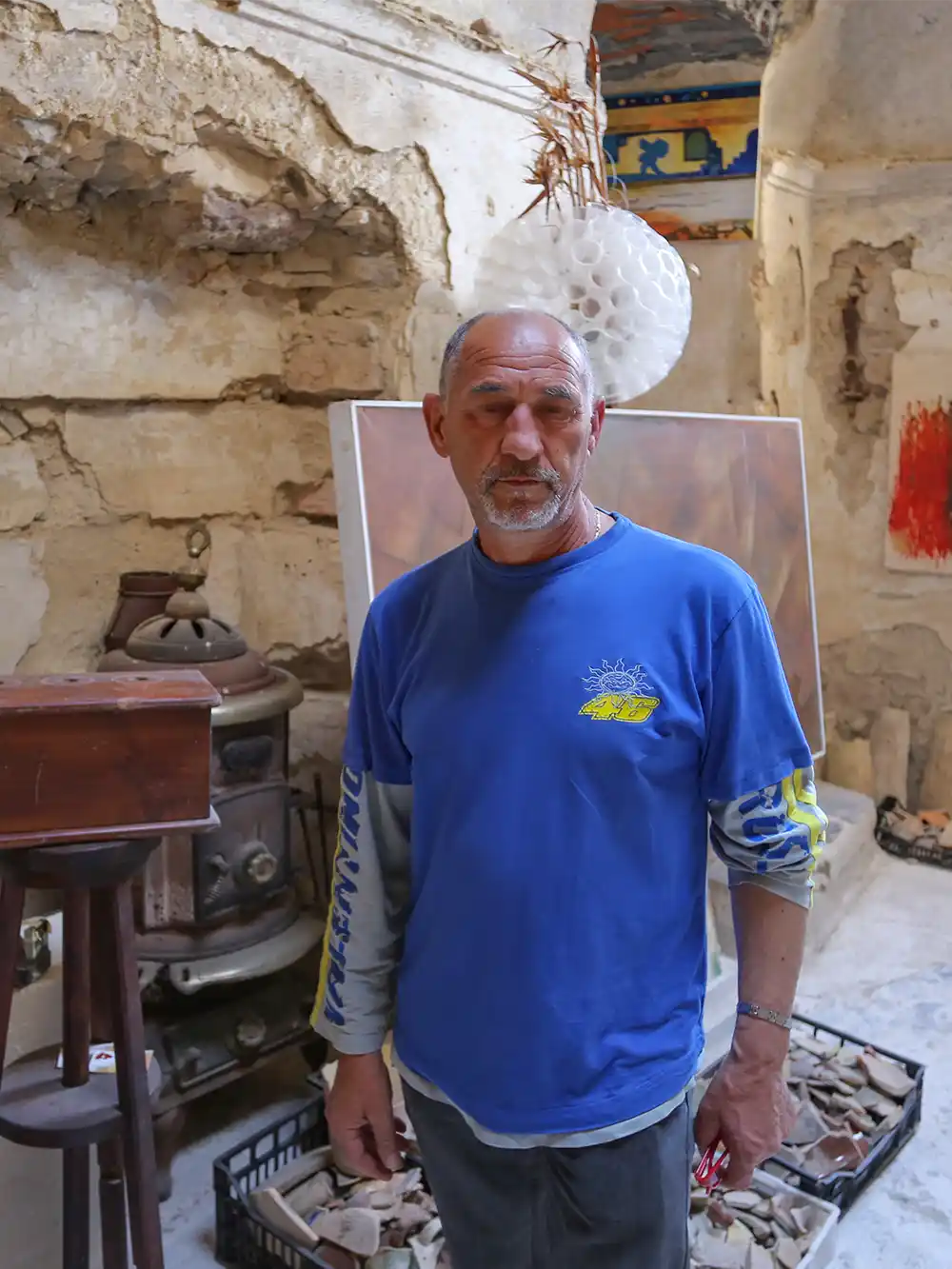 Älterer Mann in blauem T-Shirt in altem Gemäuer