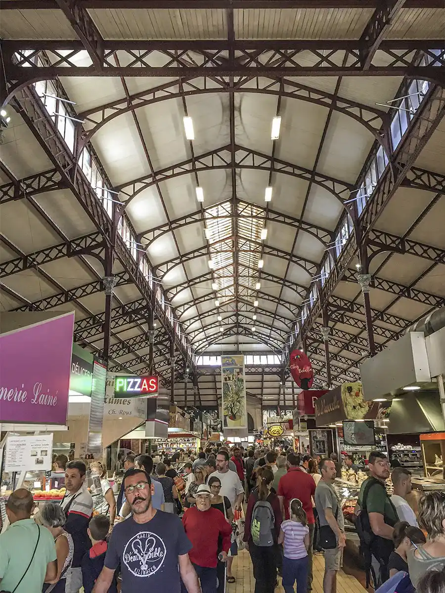 Die Markthalle von Narbonne mit vielen Menschen und einem roten Stahldach