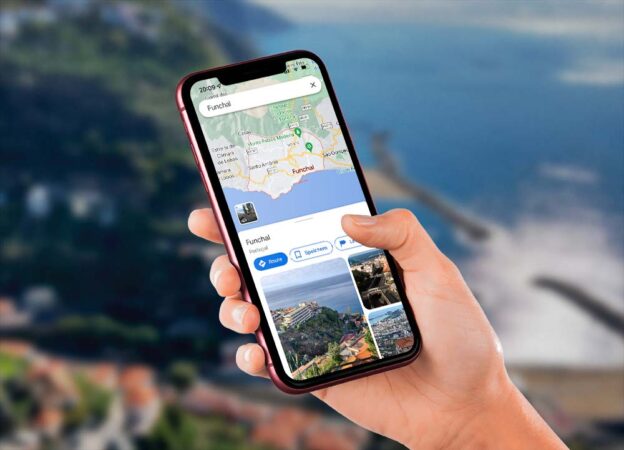 Hand mit Handy und Google Maps mit Funchal