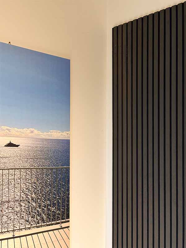 Holzpaneele-Wohnzimmer Links ein Bild vom Meer an der Wand, rechts schwarze Holzpaneele