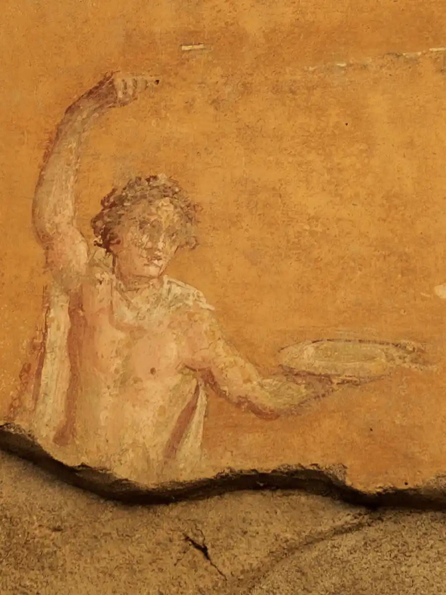 Pizza-Junge-Pompeji Antikes Fresko eines Mannes, der in der Hand einen runden Fladen hält, vor einem verblassten ockerfarbenen Hintergrund.