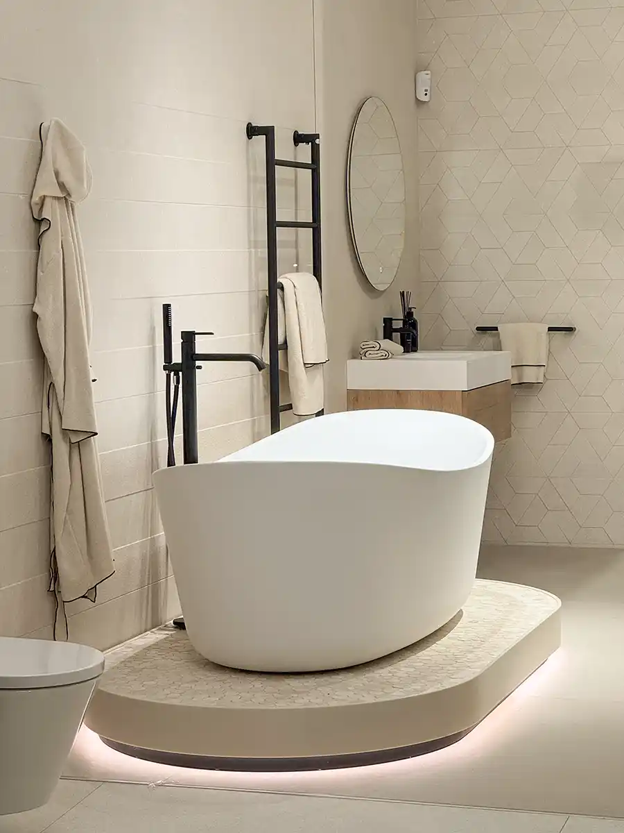 Badezimmer-mediterran-warme-Farben-Portugal Modernes, minimalistisches Bad mit freistehender Wanne, rundem Spiegel, Handtuchhalter und neutralen Farbtönen.