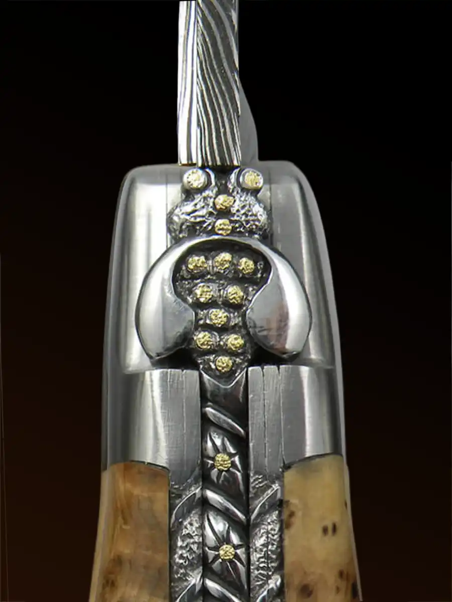 Laguiole-Messer-Biene-Mouches Nahaufnahme eines dekorativen Messergriffs mit Bienenmotiv und komplizierten Metall- und Holzdetails und goldenen Akzenten.