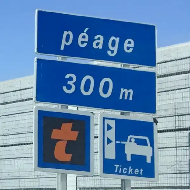 Blaues französisches Straßenschild: péage 300 m mit Symbolen für Mautticket und elektronische Mauterhebung.