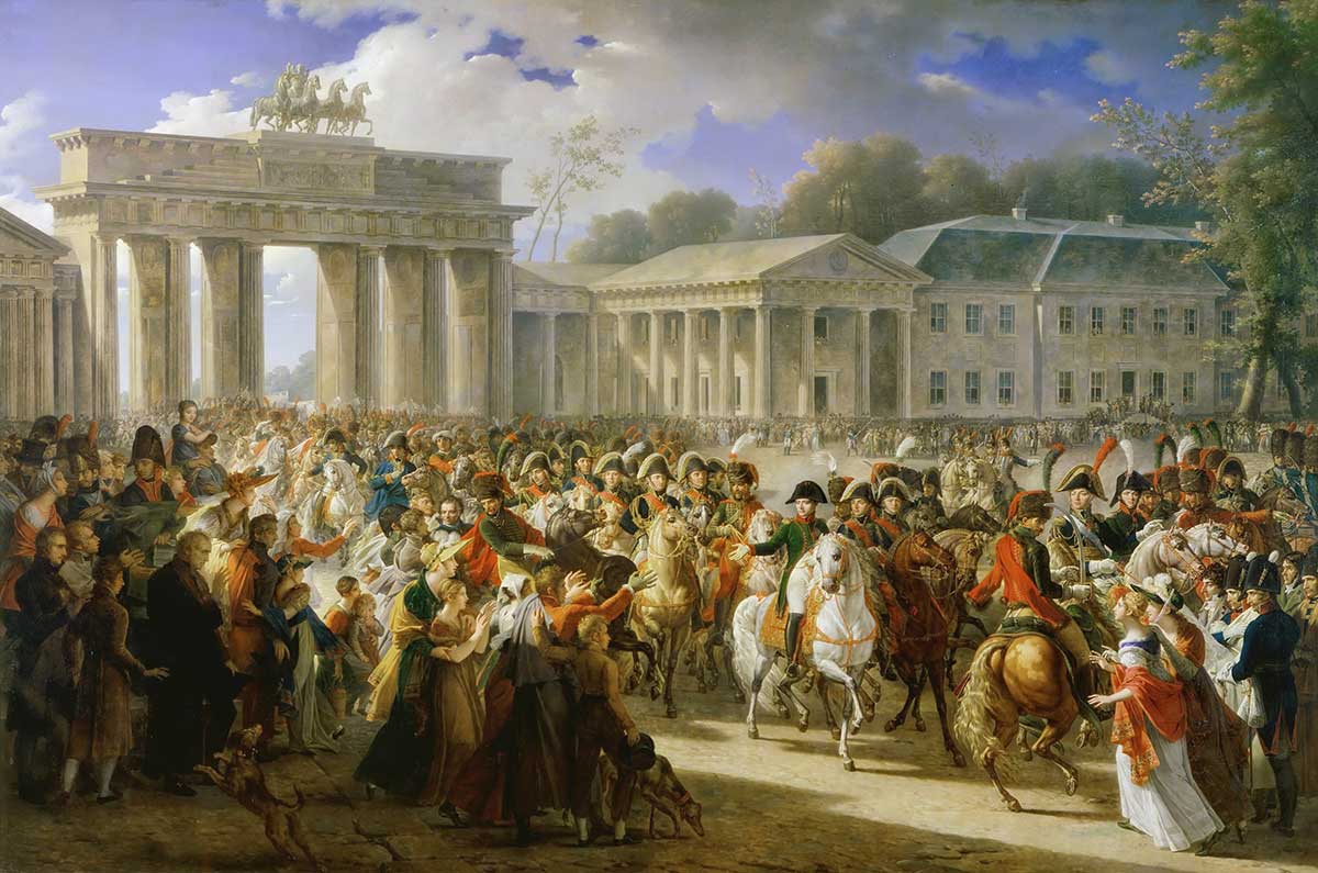 Napoleons-Einzug-Berlin-1806 Eine große Menschenmenge begrüßt die Reiter in der Nähe des Brandenburger Tors in einer historischen Stadtszene.