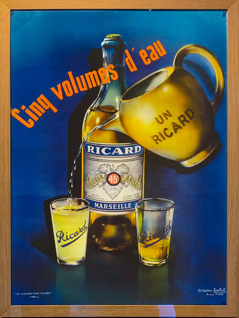 Eine Ricard-Flasche mit zwei Gläsern und einem Krug, der Wasser einschenkt; Text: Cinq volumes d'eau.