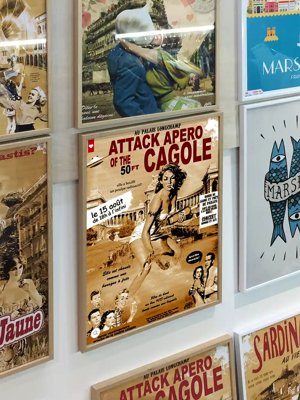Gerahmtes Poster im Vintage-Stil mit dem Titel Attack Apero of the 50 Ft Cagole an einer Wand mit anderen Postern.