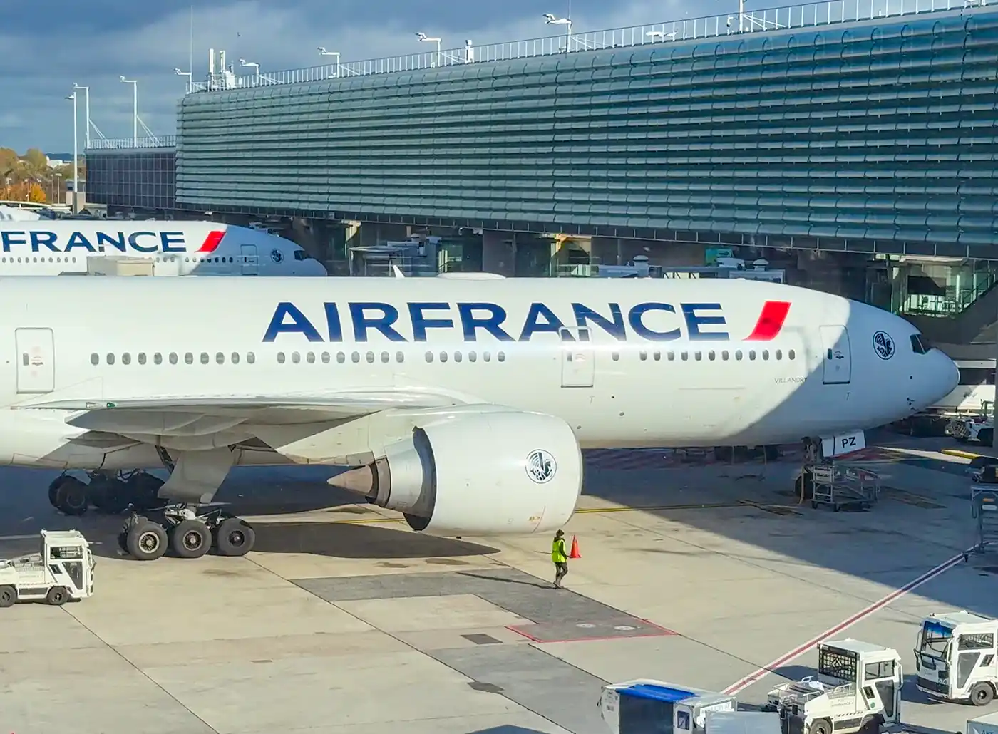 Ein Flugzeug der Air France, das an einem Flugsteig geparkt ist, im Hintergrund das Terminalgebäude.