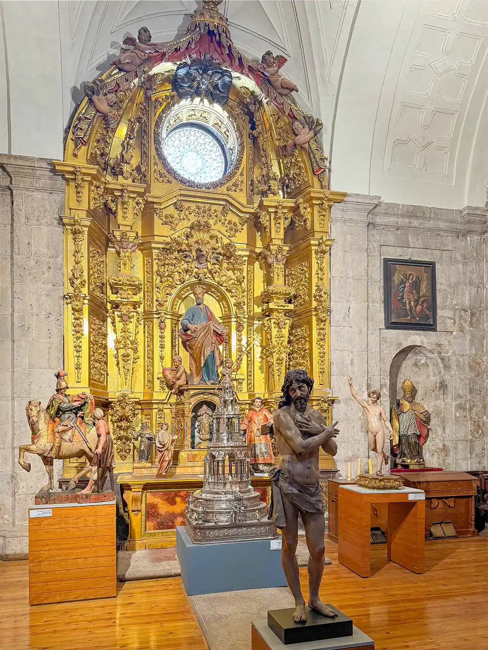 Valladolid-Kathedrale-innen Museumsraum mit religiösen Statuen, einem goldenen Altar und Kunstwerken, die an den Wänden und auf Sockeln ausgestellt sind.