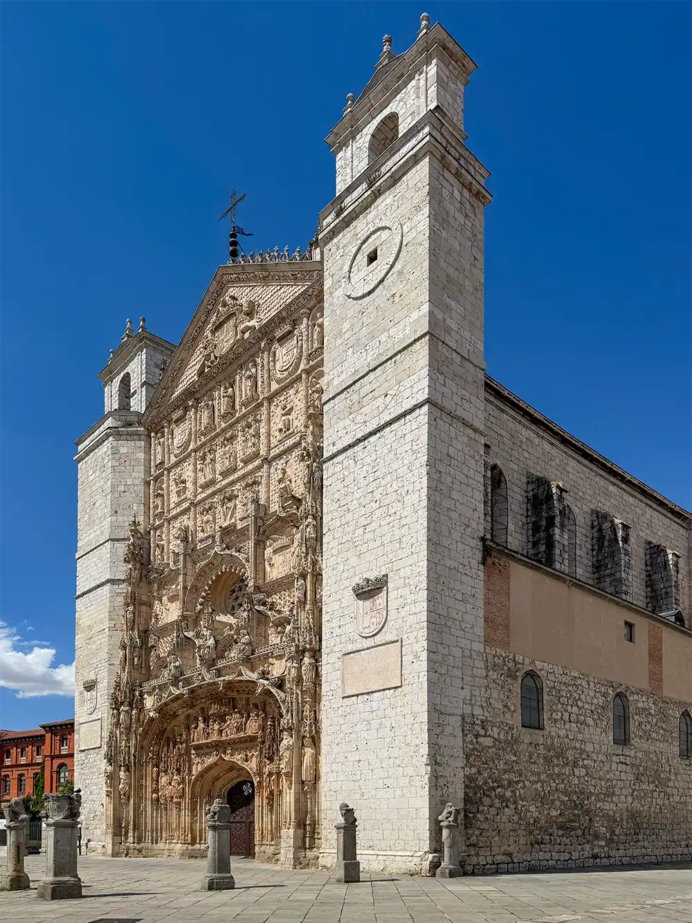 Valladolid-Kirche-San-Pablo-Seite Eine Steinkirche im gotischen Stil mit kunstvoller Fassade und zwei quadratischen Türmen unter strahlend blauem Himmel.
