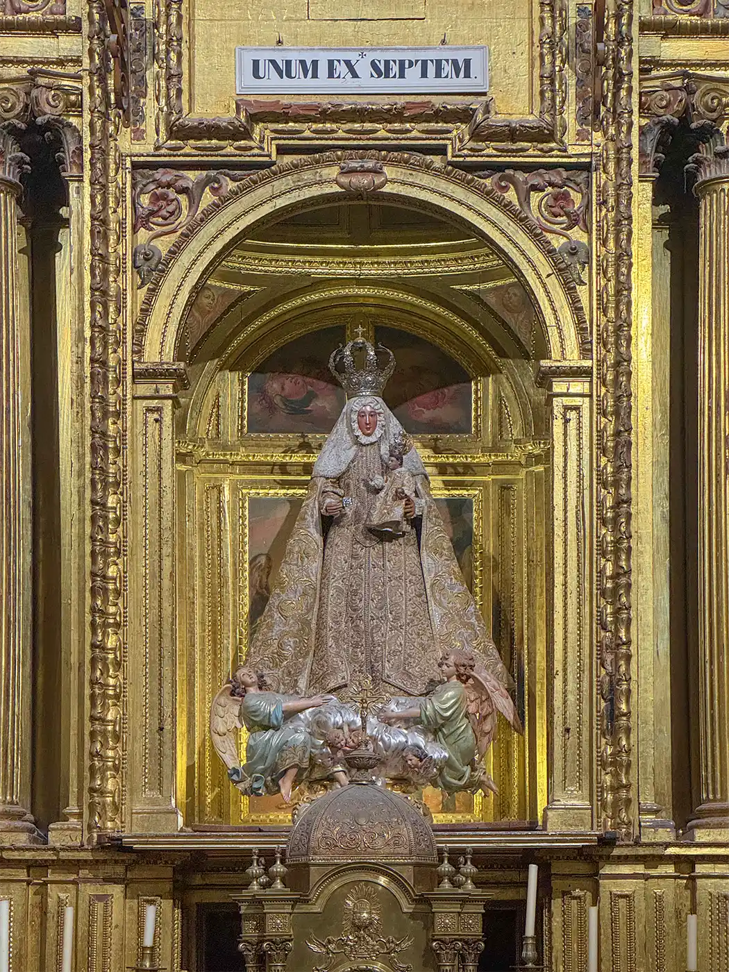 Cuenca-Kathedrale-unum-ex-septem Vergoldeter, reich verzierter Altar mit einer gekrönten Statue der Jungfrau Maria über einer kleineren Figur; darüber ein lateinischer Text.