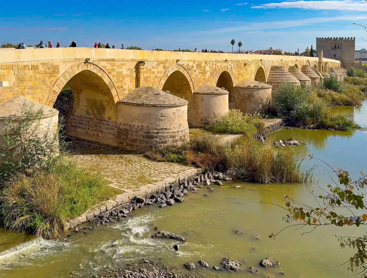 Cordoba-Puente-Romano Eine antike römische Steinbrücke, die einen Fluss in Córdoba, Spanien, überspannt.