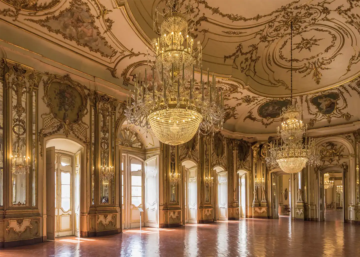 Istanbul-Dolmabahce-Palast-Saal Ein prächtiger, mit Gold verzierter Ballsaal mit zahlreichen Kristallkronleuchtern und Bogenfenstern.
