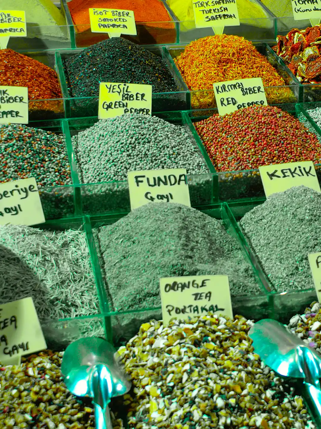 Istanbul-Gewuerzbasar-Gewuerze Körbe mit verschiedenen Gewürzen, Kräutern und Teesorten mit handgeschriebenen Etiketten auf einem Markt.