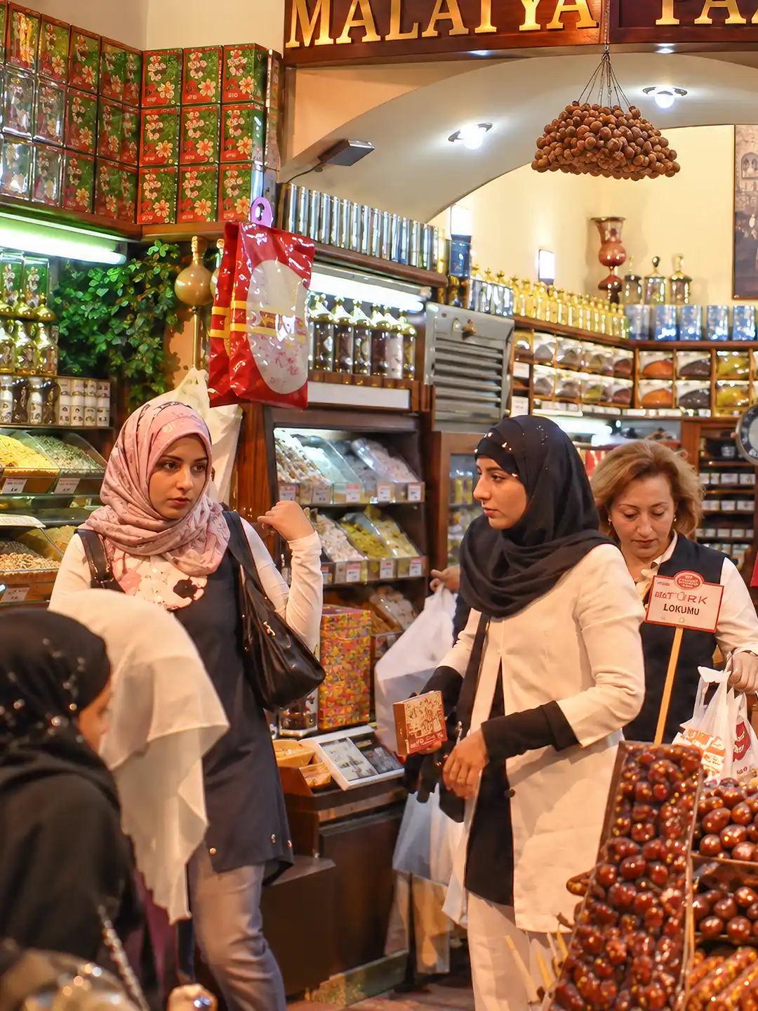 Istanbul-Gewuerzmarkt-Laden-2 Kunden, die in einem Marktgeschäft Trockenobst, Nüsse und Lokum kaufen.