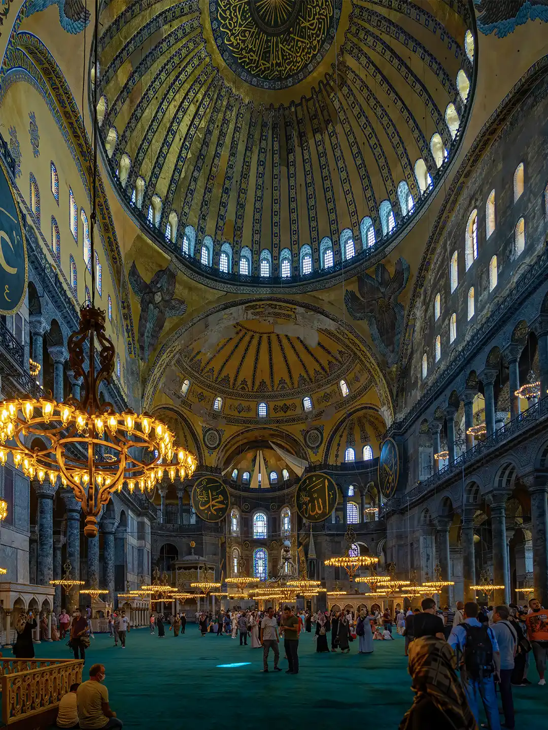 Istanbul-Hagia-Sophia-Moschee Das prächtige Innere der Hagia Sophia mit ihrer gewaltigen zentralen Kuppel, den kunstvollen Kronleuchtern und den zahlreichen Besuchern.