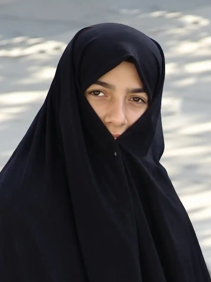 Istanbul-Muslima Eine junge Frau, die ein schwarzes Kopftuch trägt mit dem das Gesicht fast vermummt ist.