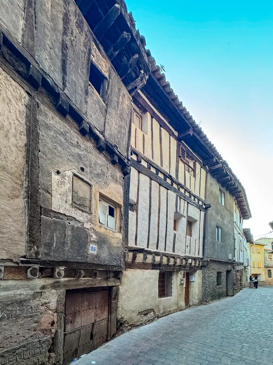 Molina-de-Aragon-Mittelalterliche-Gassen Eine schmale Kopfsteinpflasterstraße, gesäumt von historischen Fachwerkhäusern in Molina de Aragón.