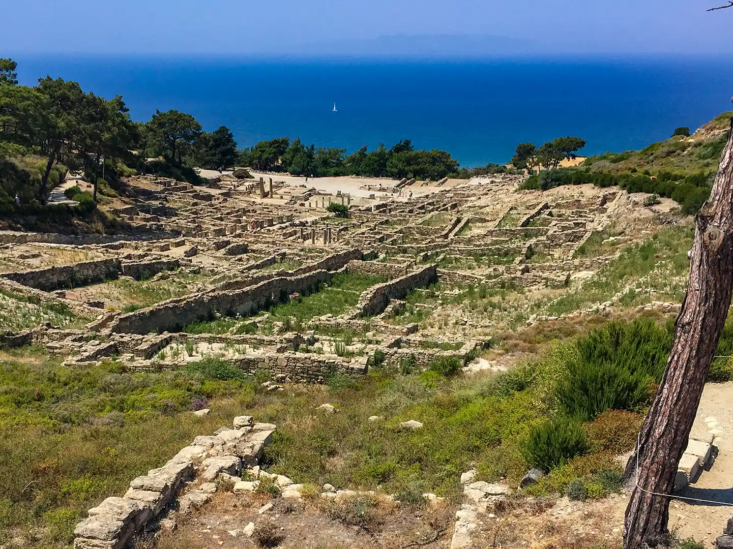Rhodos-Kamiros-Ausgrabungen Alte Steinruinen an einem Hang im antiken Kamiros mit Blick auf das Meer.